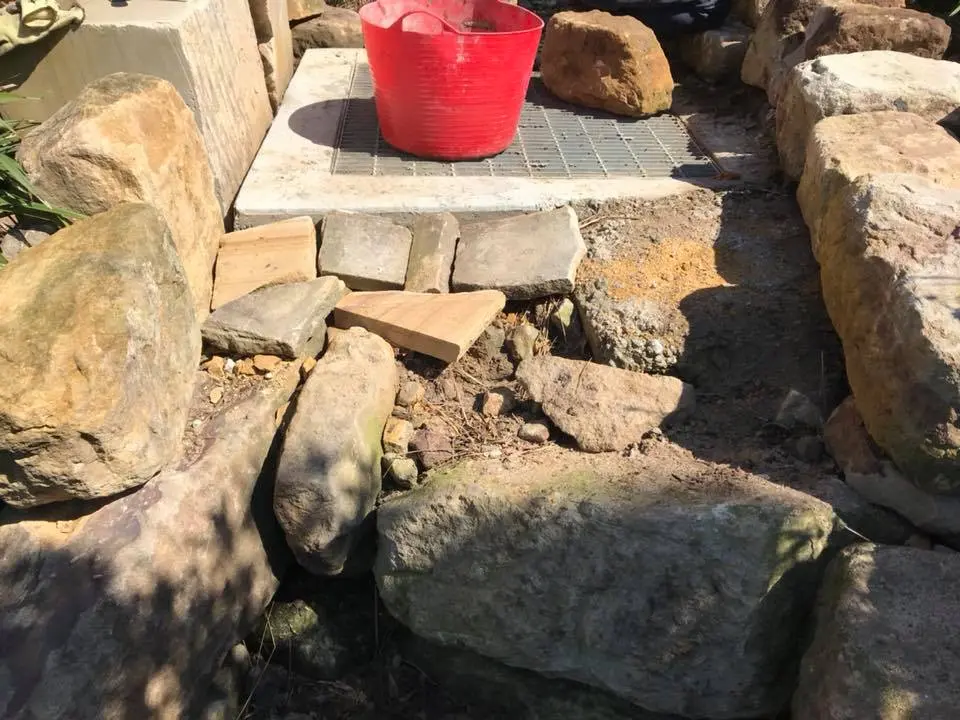 Stone-lined drainage inlet built into conservation landscaping