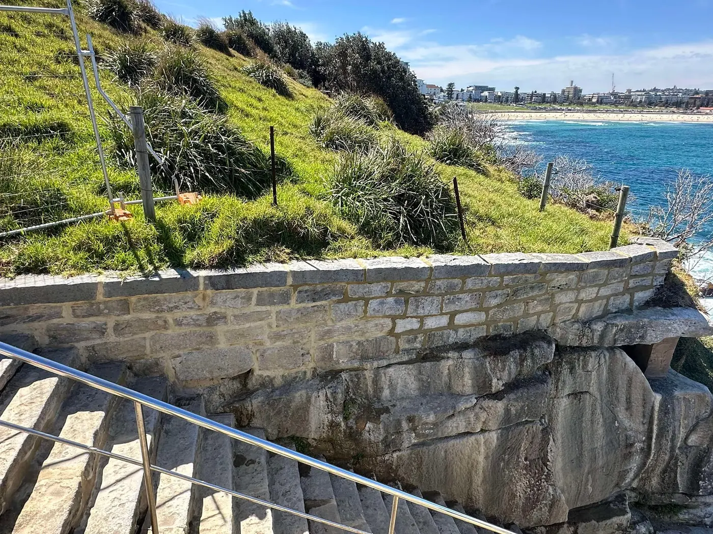 Completed sandstone retaining wall beside coastal steps